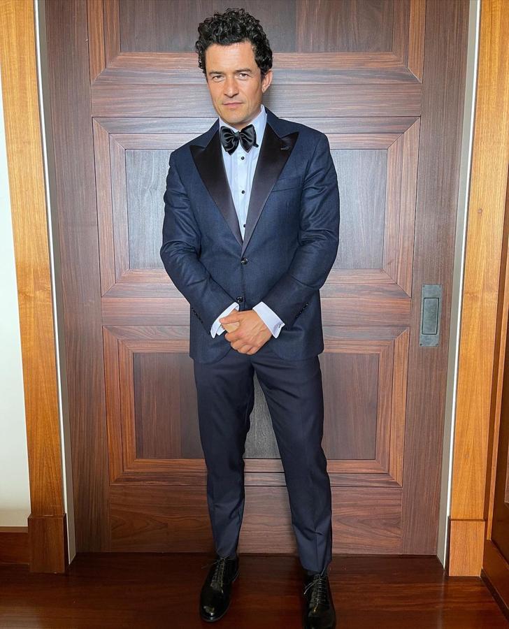 Orlando Bloom – Los mejores looks masculinos de los Critics’ Choice Awards 2021. Optó por un traje de corte slim fit con acabado satinado en azul noche con solapas negras y pajarita. Todo de Brunello Cucinelli.