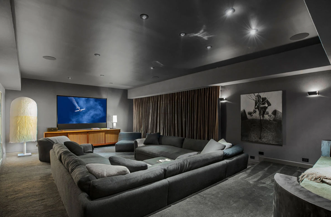 Así es la propiedad que vende Ellen DeGeneres. La vivienda dispone también de un comedor con una barra con fregadero, una biblioteca/oficina forrada con panales de madera negro azabache y chimenea y una sala de proyección, decorada en tonos grises y con un amplio sofá en U, situada en la planta inferior.