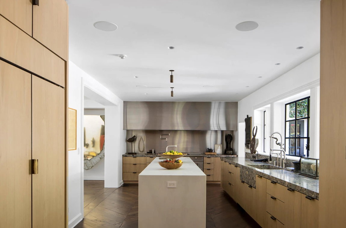 Así es la propiedad que vende Ellen DeGeneres. La cocina, que resulta bastante amplia, cuenta con muebles de madera hechos a medida, encimeras de mármol, un frente de fuegos industrial y una isla central con fregadero y espacio extra de almacenaje.