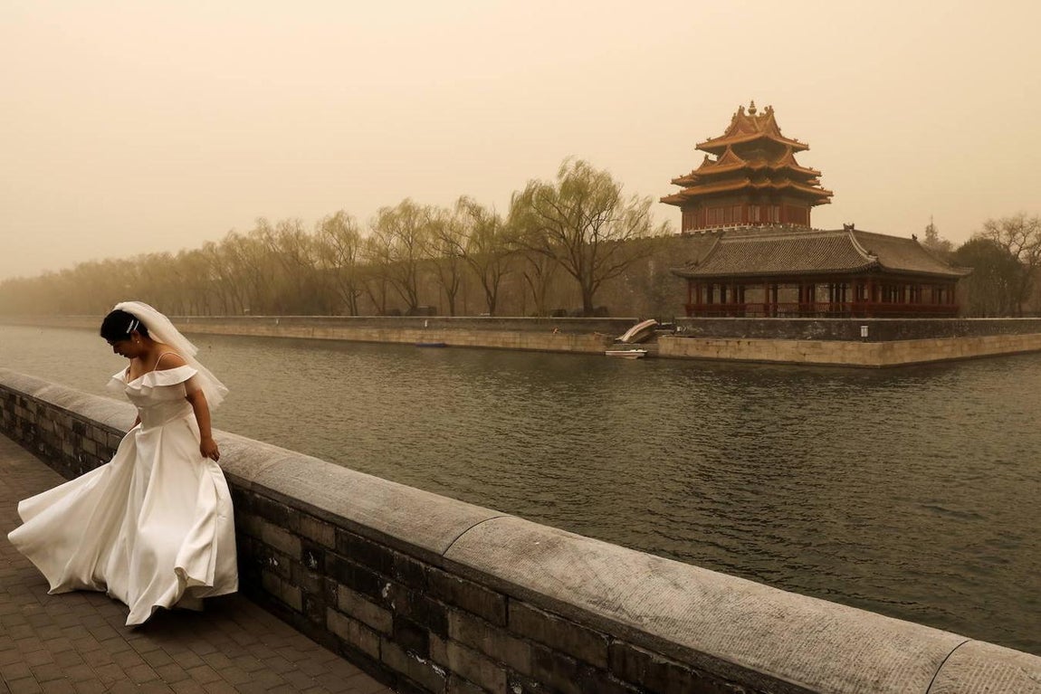 Una novia posa con su vestido durante la tormenta de arena. 