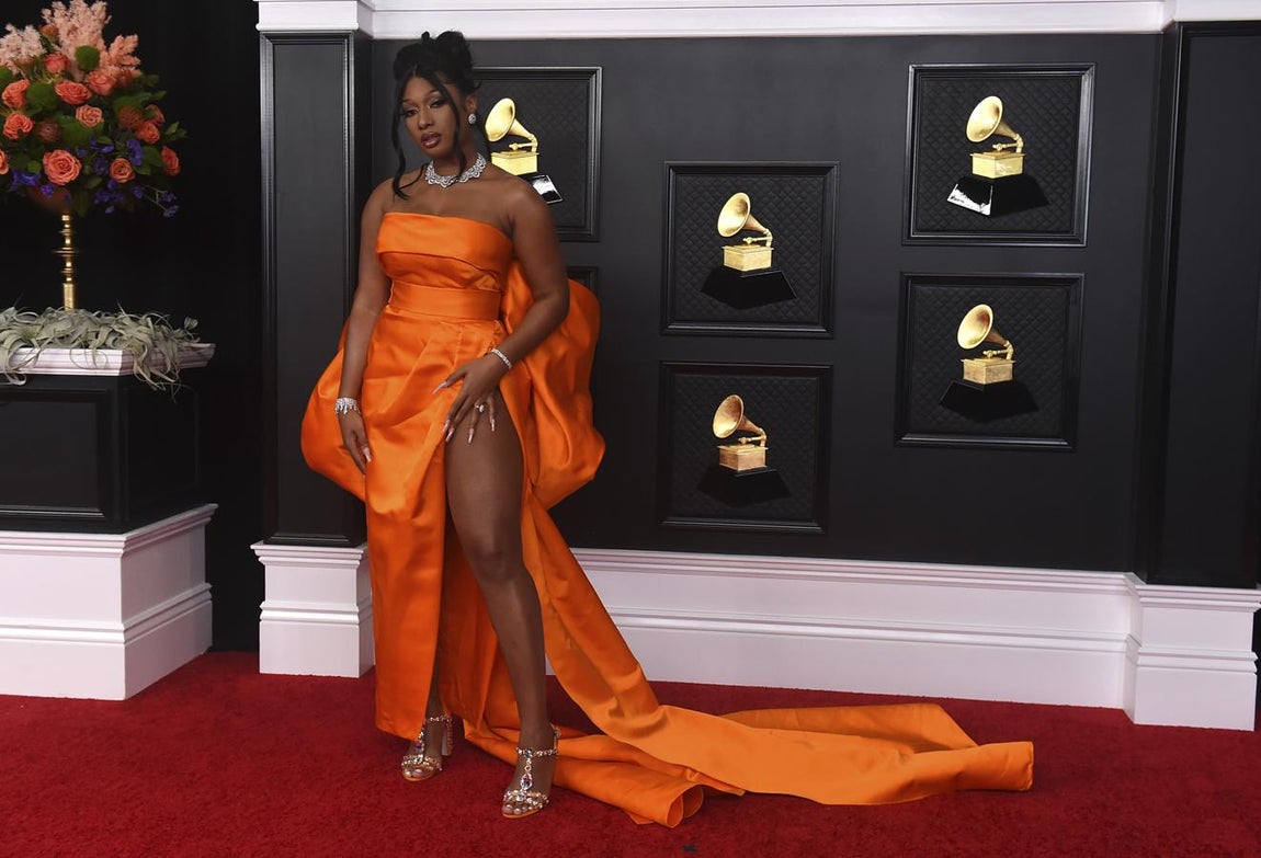 Megan Thee Stallion, en la alfombra roja de los Premios Grammy 2021. Con vestido palabra de honor en un llamativo color naranja de Dolce &amp; Gabbana.