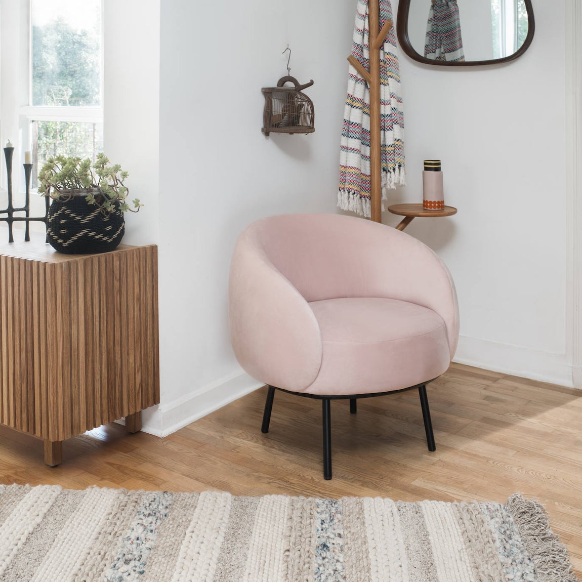 Si el detalle de color y carácter quiere ser algo más discreto, una buena opción es añadir una butaca con un diseño y un tono diferentes al resto del ambiente, como esta de terciopelo rosa de Habitat, modelo Cajou (499€).. 