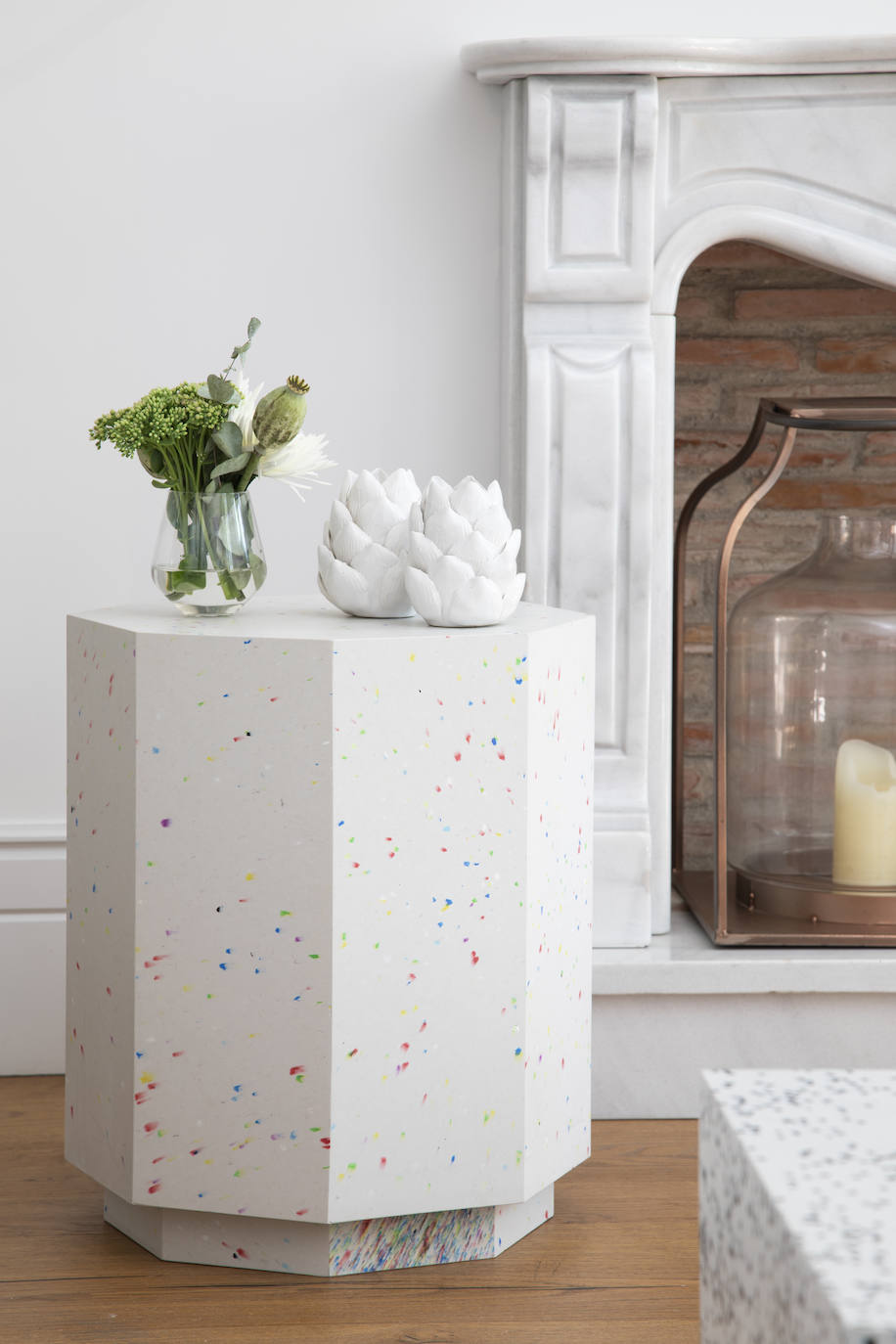 Los muebles de Revolución Limo están fabricados en su totalidad con plástico reciclado. Esta mesa auxiliar blanca con chispas multicolor aporta el toque de diseño y se adapta a un amplio rango de estilos (475€, medidas 50x60 cm).. 