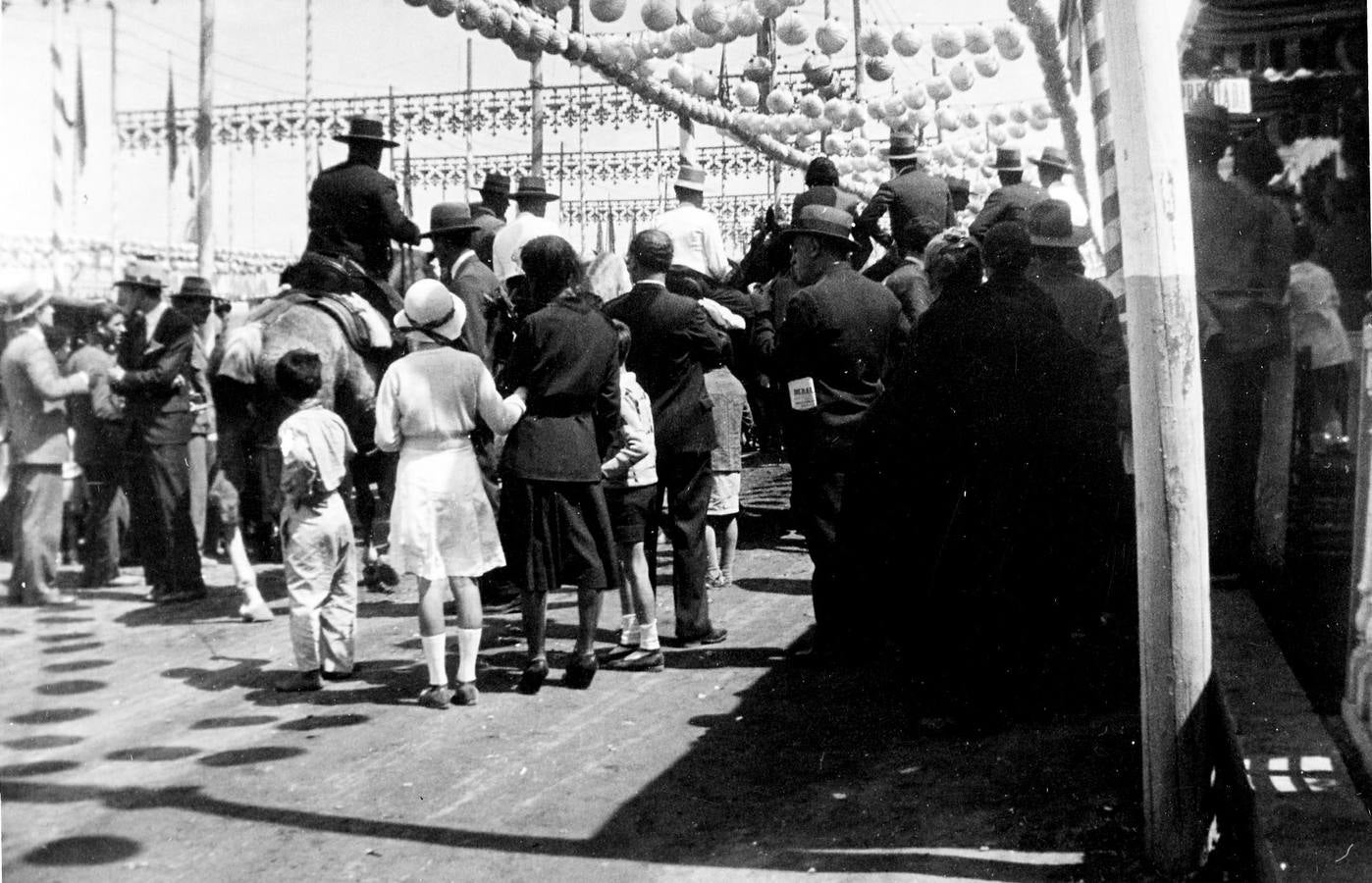 El público siguiendo a los caballistas por el paseo central de la Feria de Abril de Sevilla de 1936