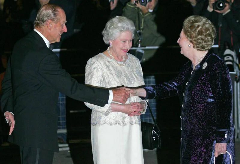 El Duque de Edimburgo y la Reina Isabel II saludan a la «Dama de Hierro», Margaret Thatcher. 
