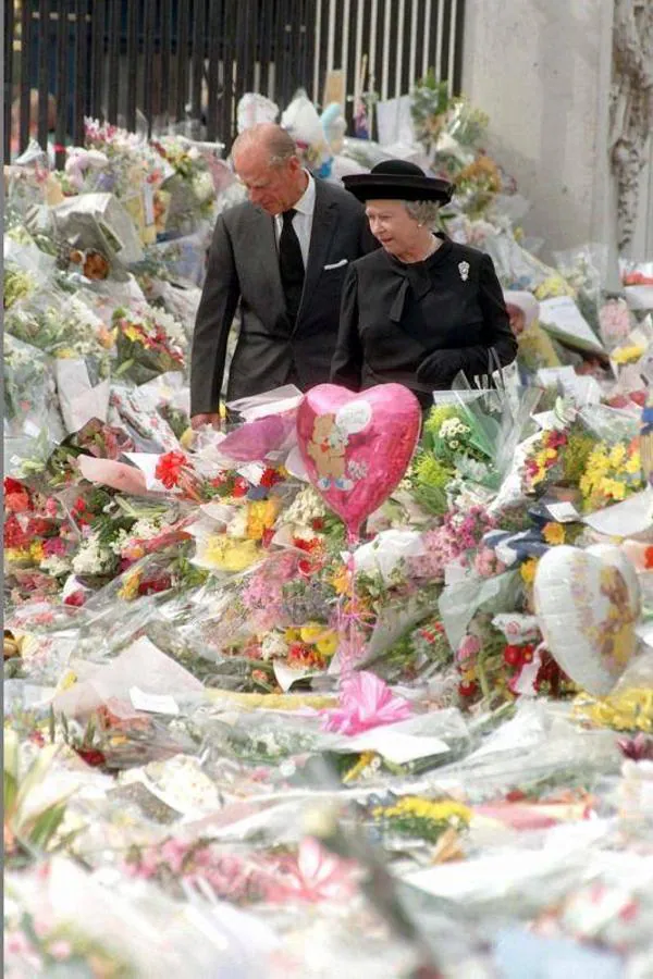 Felipe de Edimburgo y la Reina Isabel II caminan por el mar de tributos florales a Lady Di. 