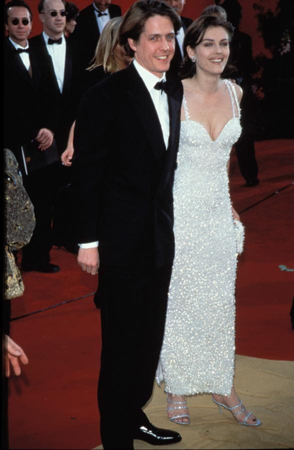 Elizabeth Hurley en 1995 - Los vestidos más icónicos de los Oscar. Oscar de la Renta es el creador de este vestido minimalista configurado por lentejuelas blancas y un llamativo escote corazón que hicieron que acaparase todas las miradas.