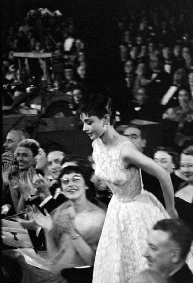 Audrey Hepburn en 1954 - Los vestidos más icónicos de los Oscar. La actriz acudió a los Oscar con una reinterpretación del vestido que lució en la película ‘Vacaciones en Roma’, por la que estaba nominada. Un diseño de Edith Head para Givenchy con cuello a la caja, semitransparencias y mucho vuelo que remató con un fino cinturón que marcaba su esbelta figura. Dicho modelo fue subastado en 2011 por la astronómica cifra de 131.292 dólares.