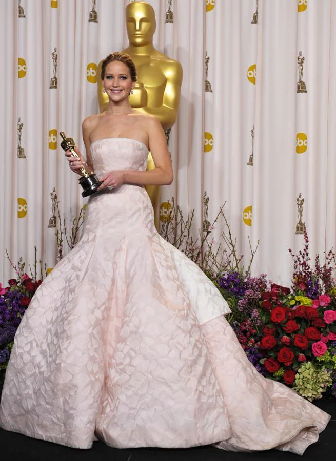Jennifer Lawrence en 2013 - Los vestidos más icónicos de los Oscar. Estamos ante uno de los vestidos más caros de la historia de los Oscar, un modelo de Dior valorado en 4 millones de dólares con el que la actriz, además, se tropezó por las escaleras del escenario al ir al recoger su premio.