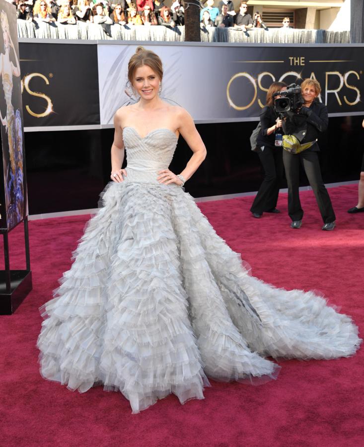 Amy Adams en 2013 - Los vestidos más icónicos de los Oscar. Su Oscar de la Renta azul celeste con plumas de gasa inevitablemente recuerda al Versace que Penélope Cruz llevó en 2007. Pero sin duda es uno de los más elegantes que hayan pisado la alfombra roja.