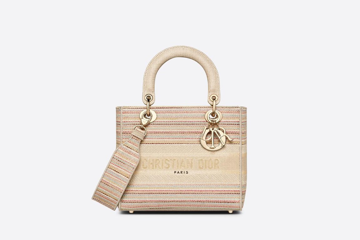 Dior. El bolso Lady D-Lite combina la elegancia clásica con la modernidad de la Maison. La pieza, que forma parte de la colección Dior Or, presenta un bordado integral de rayas finas multicolores en tonos pastel y la firma “Christian Dior”. Cuenta además con charms “D.I.O.R.” de metal con acabado dorado y dispone de una bandolera ancha bordada extraíble y reversible ofreciendo distintas posibilidades de llevarlo tanto en la mano, como colgado del hombro o cruzado. Precio: 4.000€