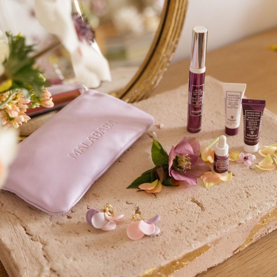 Malababa y Sisley. Dos marcas premium como Malababa y Sisley se unen en una propuesta que hará las delicias de toda madre que la reciba. La belleza en el mundo de la cosmética y de la moda tienen la responsabilidad de mimar el entorno y crear un concepto y unos cánones estéticos adecuados, máxima que ambas marca comparten. Este kit compuesto por una cartera de piel y los famosos pendientes pétalo de Malababa, incluye además el contorno de ojos Fluide Contour des Yeux à la Rose Noire, acompañado de 3 minitallas para el ritual completo del rostro. Precio: 177€ (valorado en 253€)