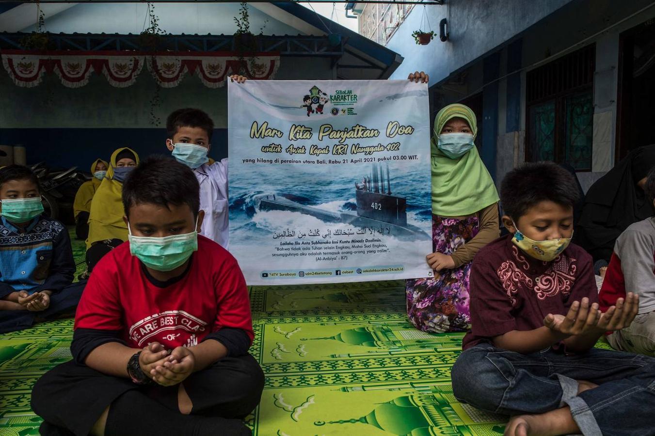 Estudiantes y profesores rezan por los 53 tripulantes a bordo de un submarino de la marina indonesia que desapareció frente a la costa de Bali durante los ejercicios de entrenamiento el 21 de abril. 