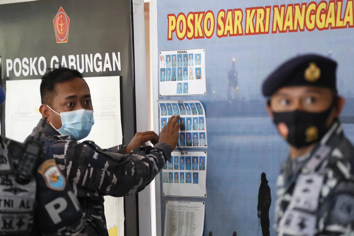 Un militar coloca en la pared las fotografías de los miembros de la tripulación del submarino desaparecido de la Armada de Indonesia KRI Nanggala. 