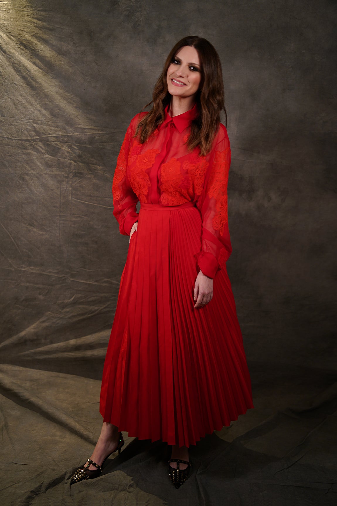 Laura Pausini con otro look para los Globos de Oro, también de Valentino, en este caso en rojo, con falda plisada combinada con blusa de transparencias. La cantante lleva tres décadas de carrera, en las que ha conseguido varios hitos y abierto puertas para las intérpretes femeninas.. 