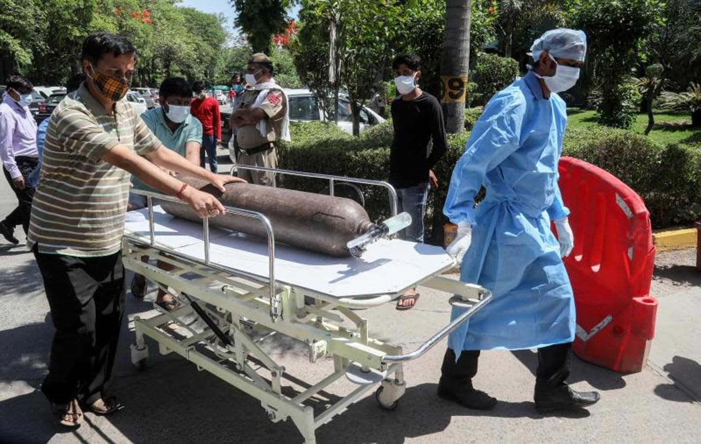 Sanitarios se apresuran con un cilindro de oxígeno en una camilla en el hospital Jaipur Golden (Nueva Delhi), donde al menos 25 pacientes con Covid-19 fallecieron la noche anterior debido a la escasez de oxígeno médico. 