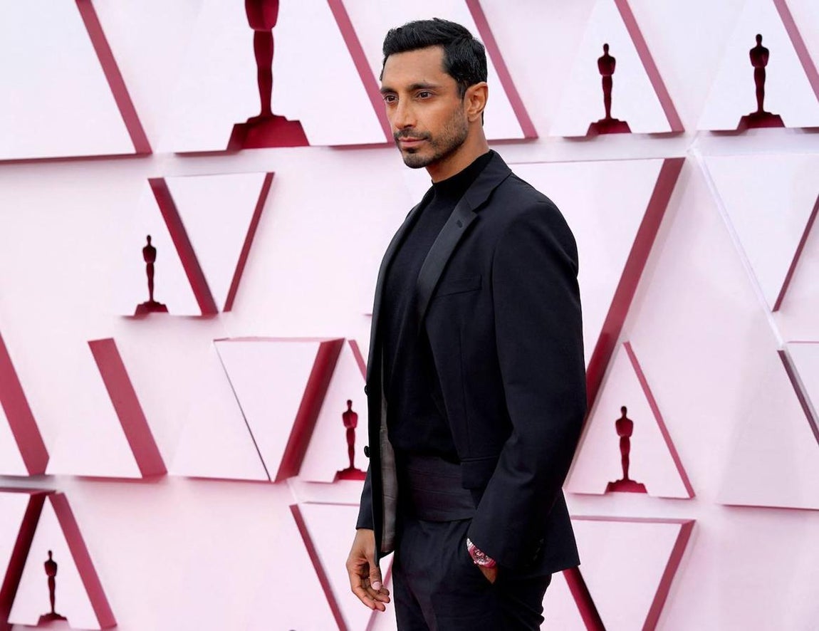 Riz Ahmed - La alfombra roja de los Oscar 2021. Optó por un look minimalista con un traje negro de Prada que combinó con una camiseta negra de cuello a la caja y un fajín satinado.