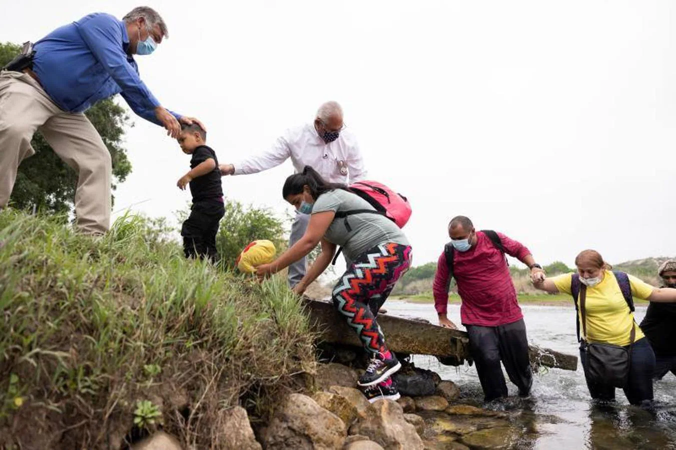 Un niño encabeza la fila de una familia de inmigrantes que consigue salir del Río Grande. 