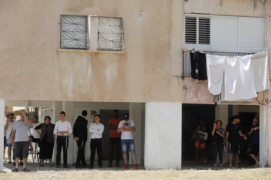 Habitantes resguardados tras el impacto del cohete en Ashkelon. 