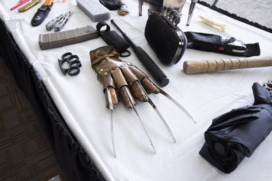 Un puño americano con forma de bolso de fiesta junto a un guante con cuchillos. 