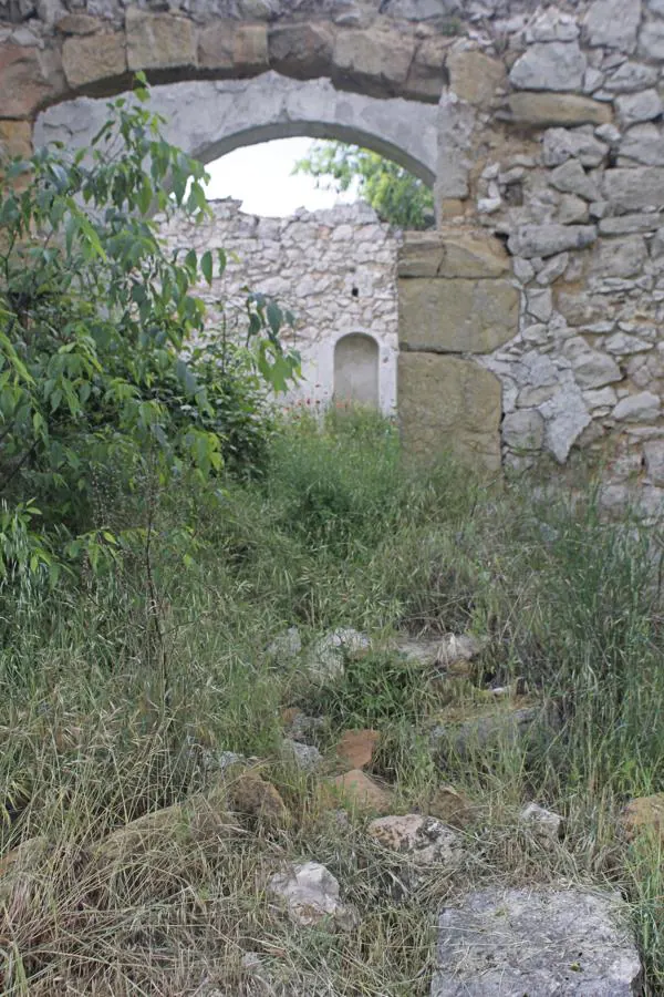 Las zarzas y las piedras caídas conducen al interior de las ruinas de la iglesia de Hontanillas. 