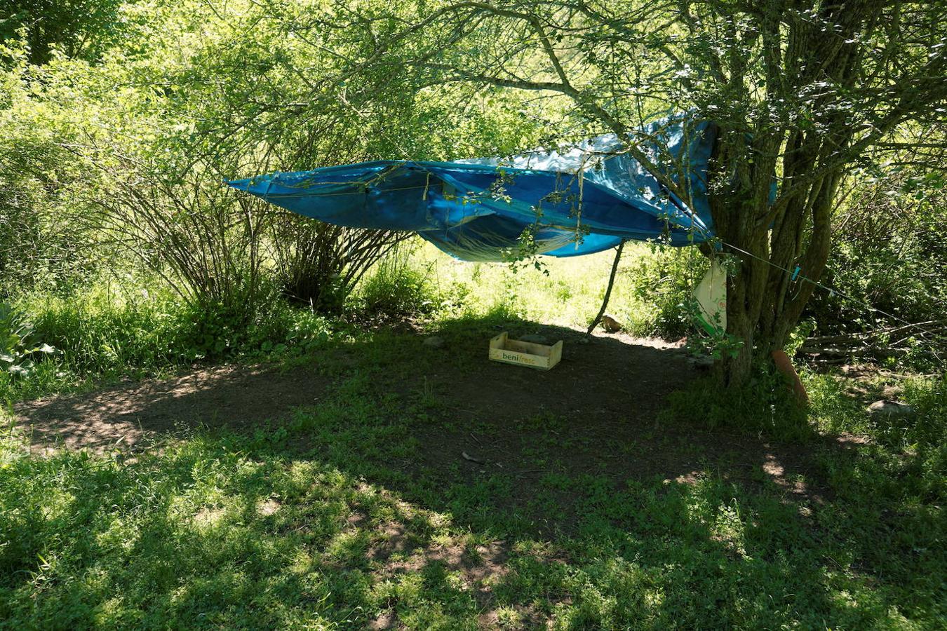 Una especie de cabaña construida con una lona en el campamento de Familia Arcoíris. 