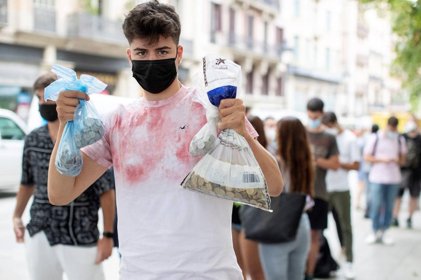 Un joven muestra una bolsa con las pesetas que va a cambiar por euros en el Banco de España de Barcelona. 