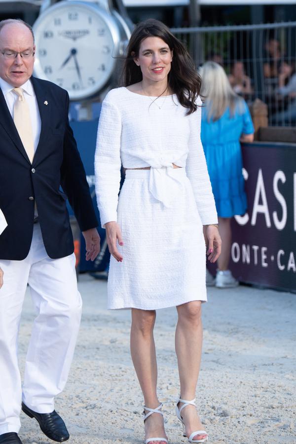 Carlota Casiraghi con un impecable look en blanco. El Campeonato de Salto de Montecarlo ha supuesto la vuelta a los focos de Carlota Casiraghi, cuyo estilo, además de ser considerado uno de los más elegantes de la realeza europea, es bastante fácil de imitar si se tienen en cuenta una serie de directrices (como por ejemplo optar por los cortes midi y escotes a la caja, de tipo halter y mangas abullonadas). Para la ocasión se decantó por un total look blanco de Chanel que, aunque se trataba de un dos piezas, simulaba ser un vestido y que combinó con unas sandalias de tiras con plataforma de metacrilato de la misma firma. Sin duda una opción muy versátil y elegante especialmente adecuada para los looks de verano en los que se busca un resultado llamativo sin tener que pensar demasiado.