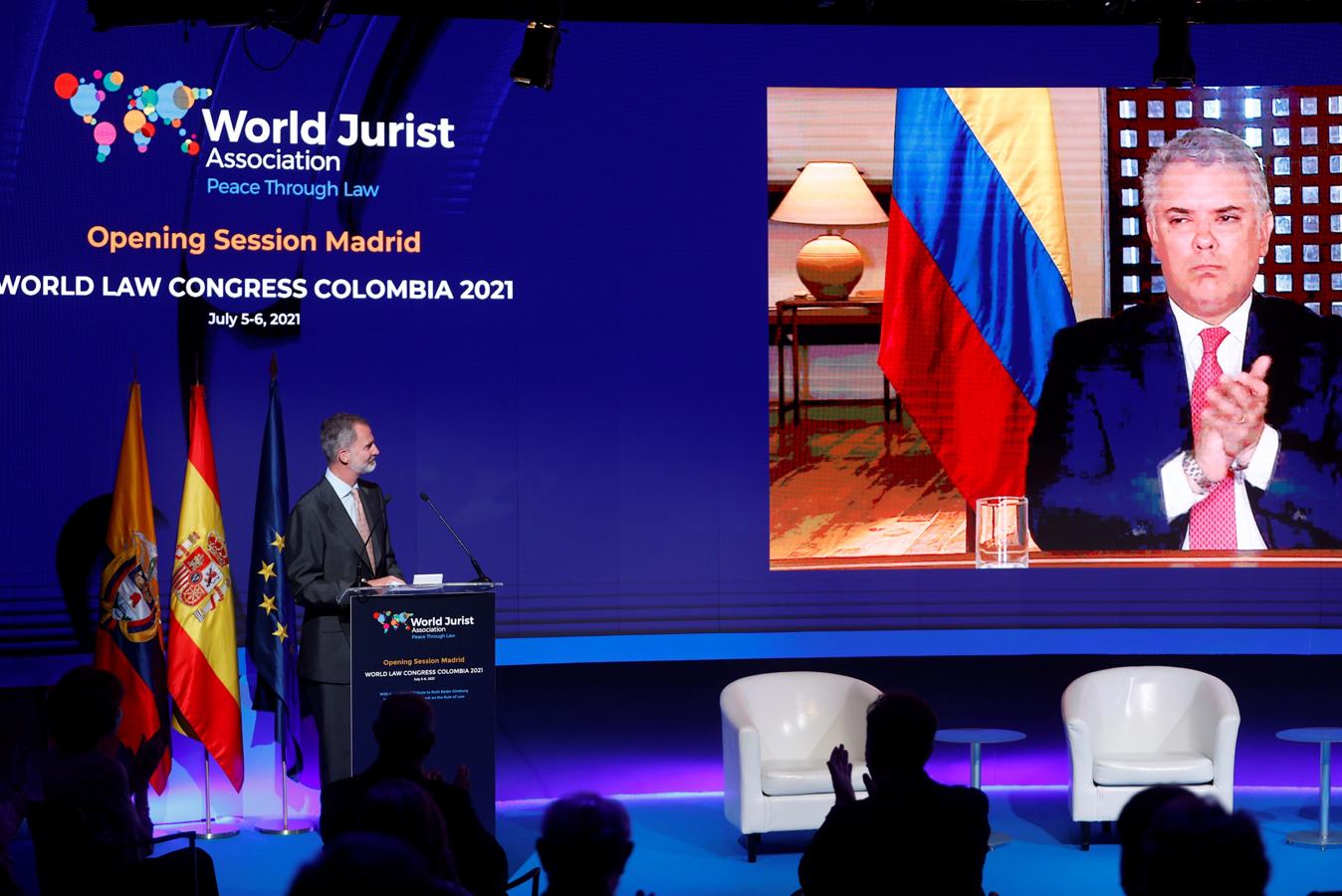 El rey Felipe VI (i) y el presidente de Colombia, Iván Duque (en pantalla), intervienen durante el Congreso que la Asociación Mundial de Juristas ha celebrado este lunes. 