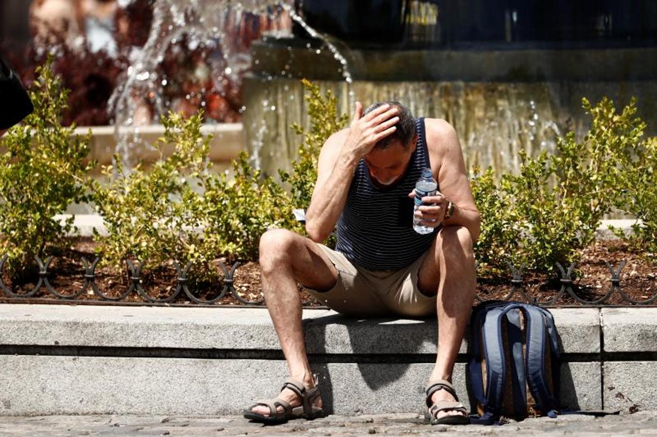 Un hombre se refresca poniéndose agua sobre la cabeza (Foto tomada en Madrid). 