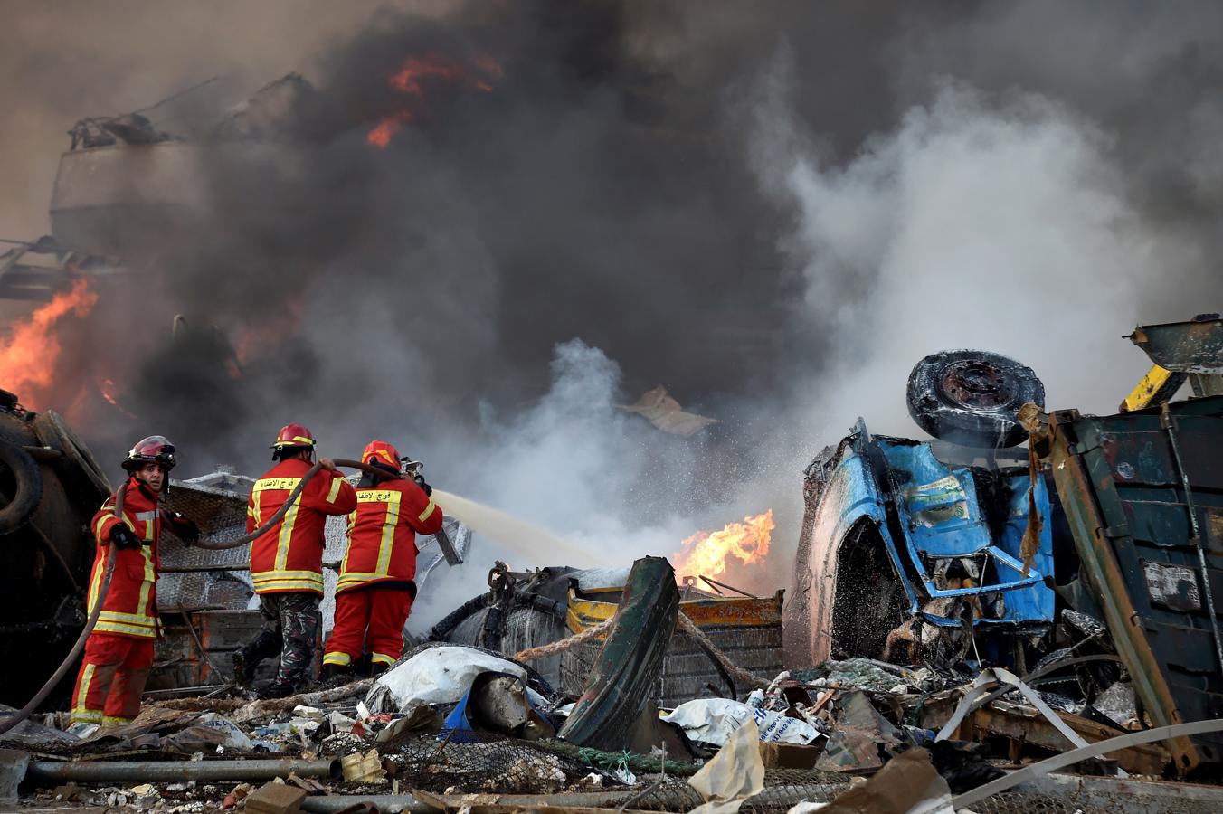 Los bomberos intentan apagar el fuego causado por el almacenamiento del nitrato de amonio en el puerto de Beirut. 