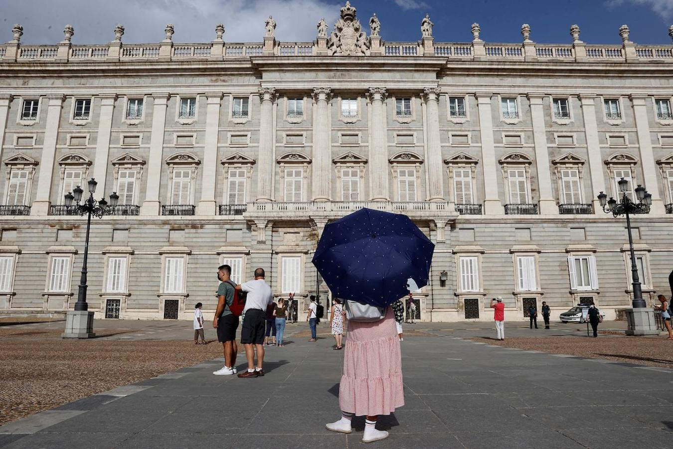 Una turista evita el sol con un paraguas en Madrid este sábado cuando el calor intenso ha puesto en alerta a casi todo el mapa de España. 