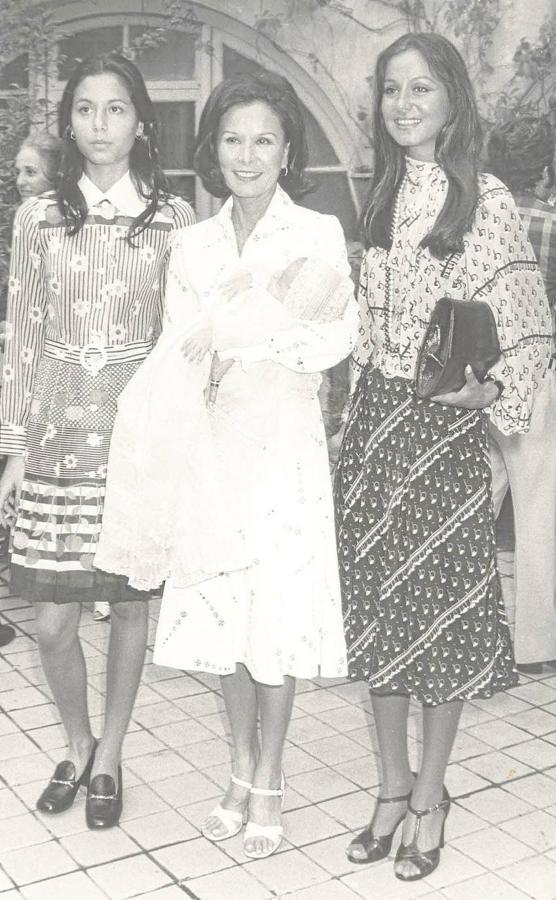 Isabel Preysler sonriente junto a su madre que sostiene a su nieto Enrique en brazos en 1973. 
