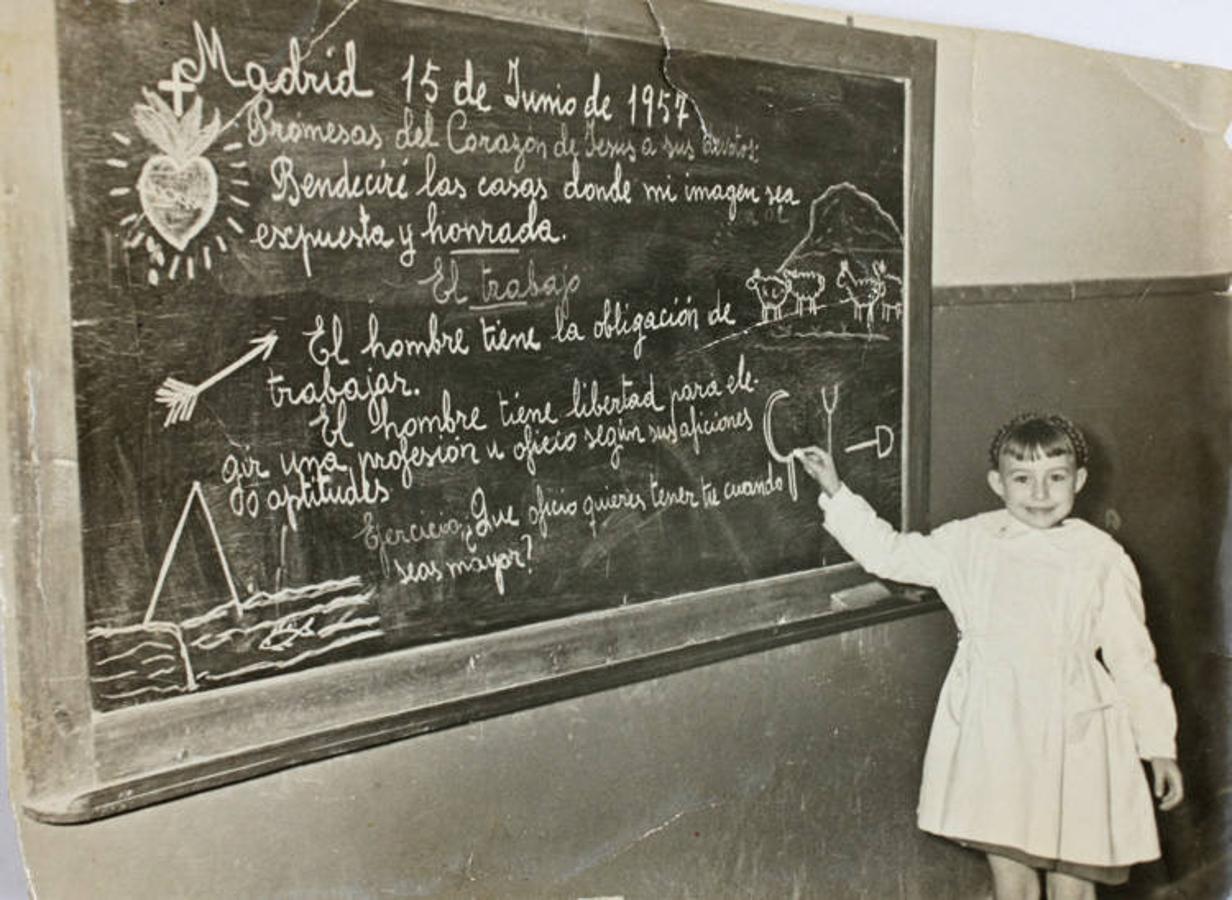 1957: Retrato de una niña escribiendo en la pizarra en un colegio de Usera. 