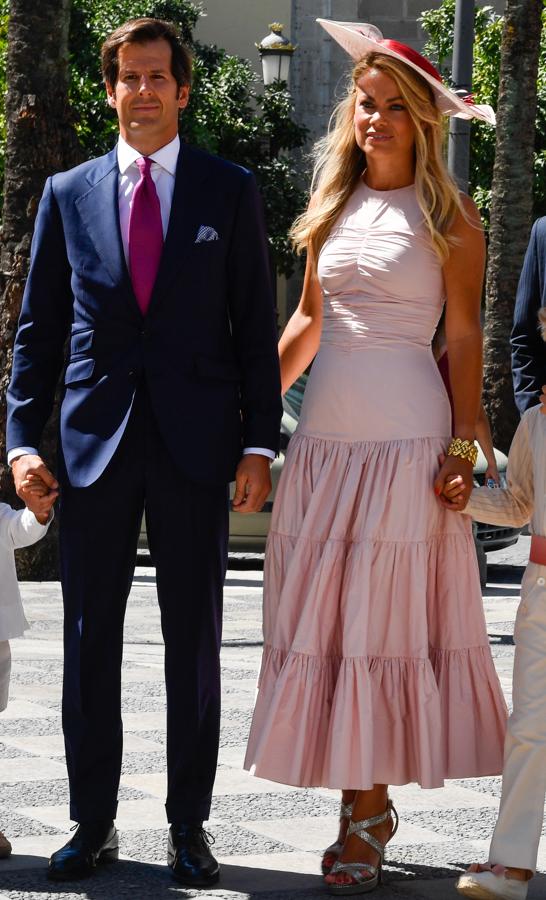 Carla Goyanes y Jorge Benguria. Llevó un diseño rosa bebé de Jacquard que presentaba una parte superior ajustada que terminaba en una falda repleta de volumen que se acortaba al tobillo y que dejaba ver sus sandalias con tiras metalizadas y plataforma. Como accesorio, una pamela del mismo tono que incluía además un lazo rojo.