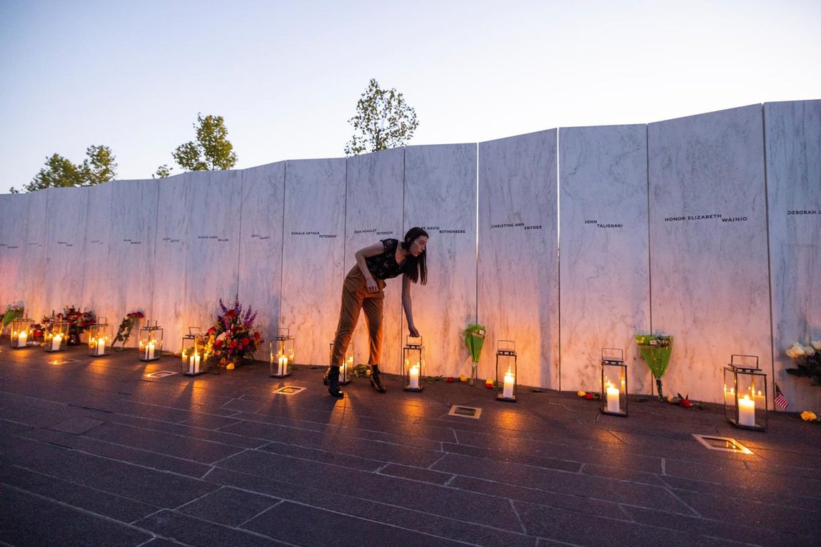 Una mujer coloca el candelabro en el piso para la vigilia a los caídos en el Vuelo 93 de United Airlines. 