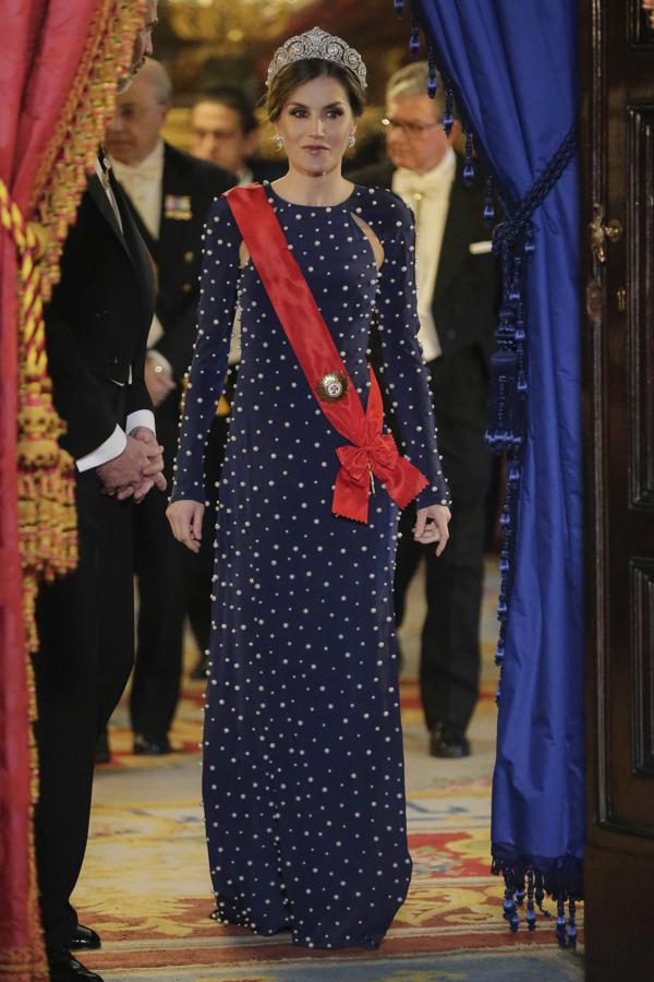 2018 - Los vestidos más icónicos de la Reina Letizia. Otro de sus vestidos más sonados es este diseño azul noche con pedrería y aberturas en los hombros que lució en la cena de gala con el Presidente de Portugal. Una pieza de Ana Locking a la que añadió una tiara de Cartier.