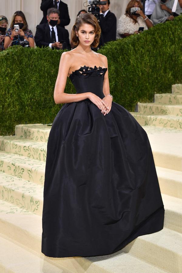 Kaia Gerber - Alfombra roja de la Gala MET 2021. Llevó un vestido de seda negro con encaje palabra de honor con flores bordadas y una falda con volumen de Oscar de la Renta.