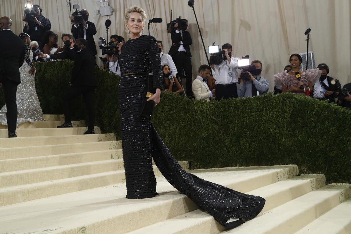 Sharon Stone - Alfombra roja de la Gala MET 2021. Se decantó por un diseño negro con líneas horizontales con lentejuelas bordadas que se ajustaba a su figura y que terminaba en una larga capa. Se trata de una creación de Thom Browne.