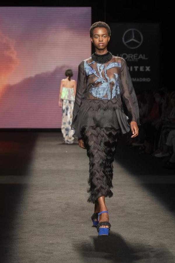 Falda estrecha adornada con plumas y camisa transparente. 