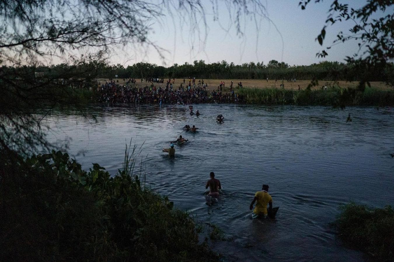 Un grupo de migrantes cruza el río para tratar de acceder al país. 