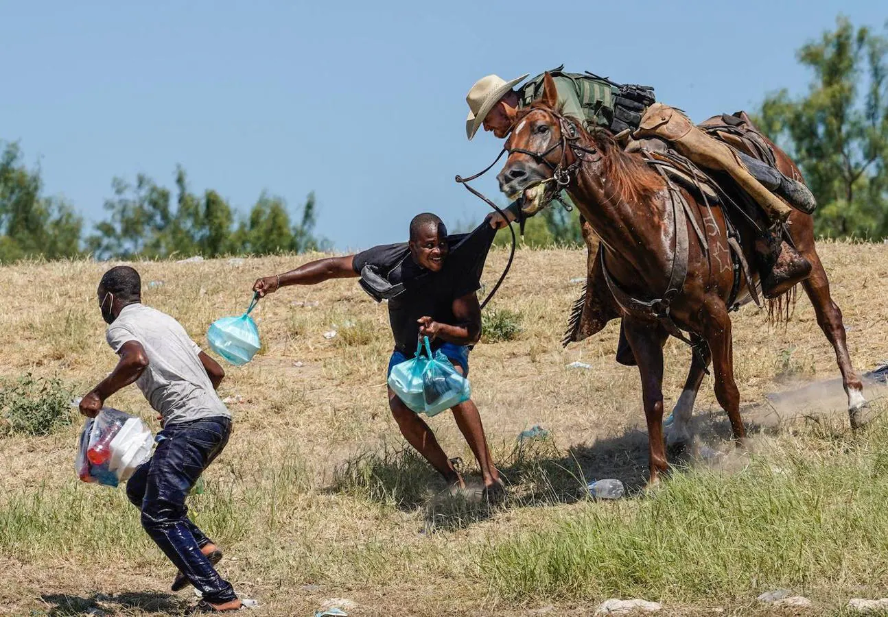 Un agente de la guardia fronteriza de Estados Unidos a caballo intenta evitar que un migrante haitiano ingrese a un campamento a orillas del Río Grande. 
