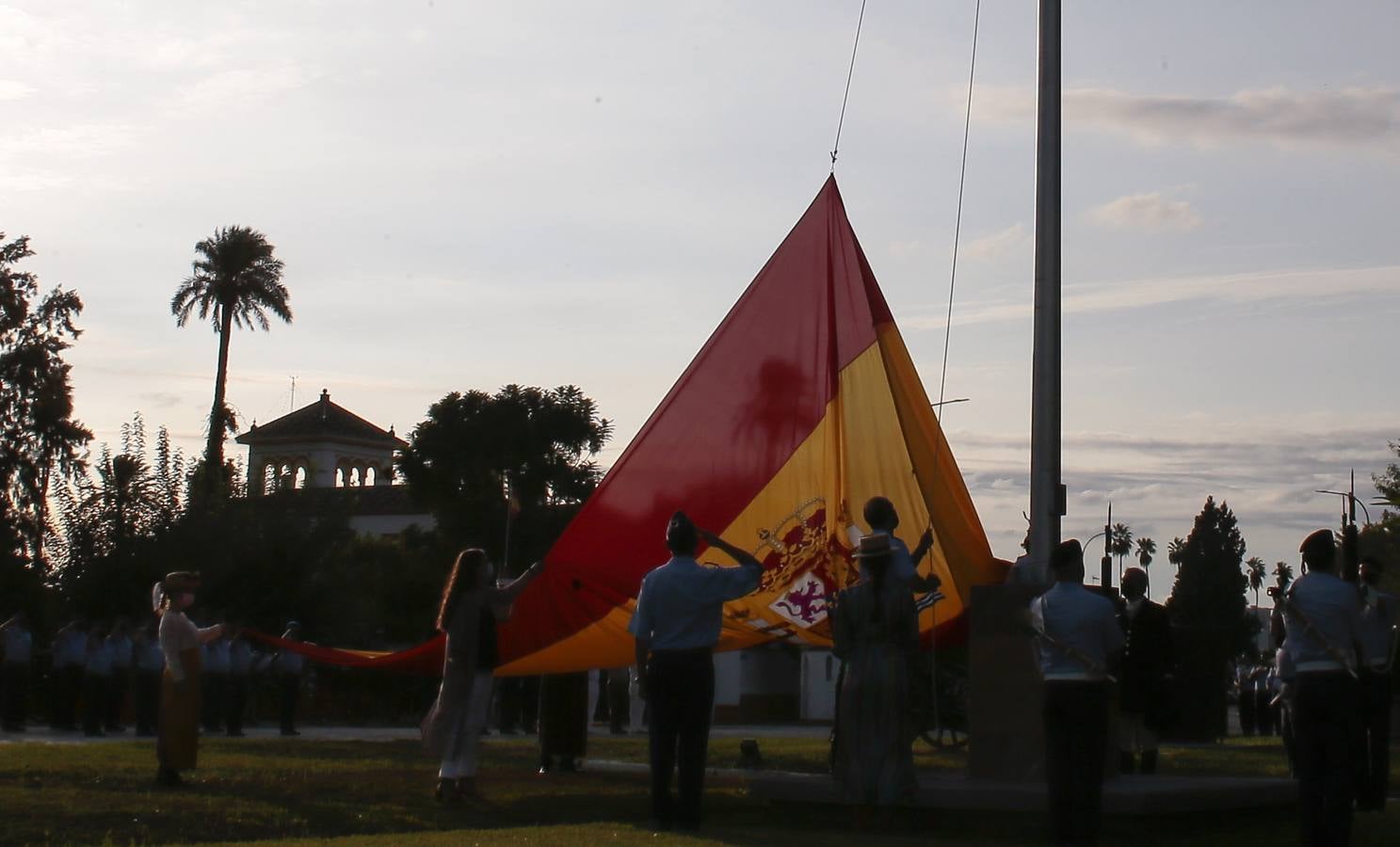 Izado de bandera en Tablada, con los carruajes participantes en el primer paseo por la ciudad.