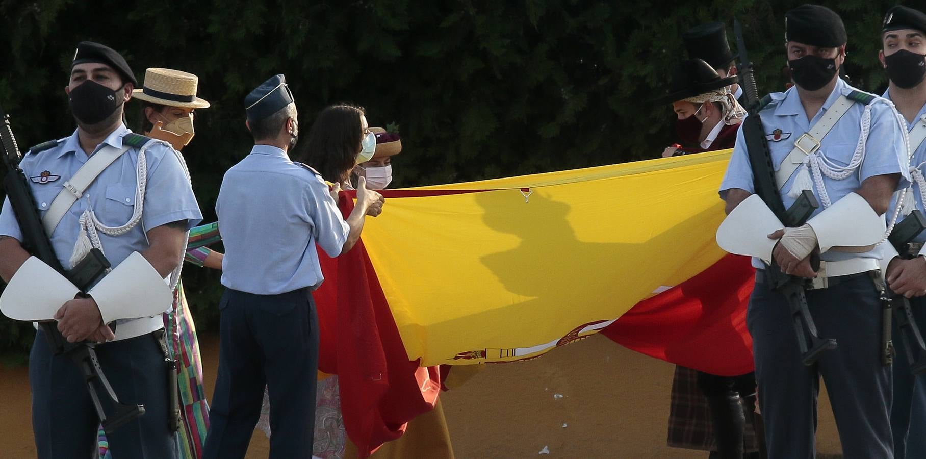 Izado de bandera en Tablada, con los carruajes participantes en el primer paseo por la ciudad.