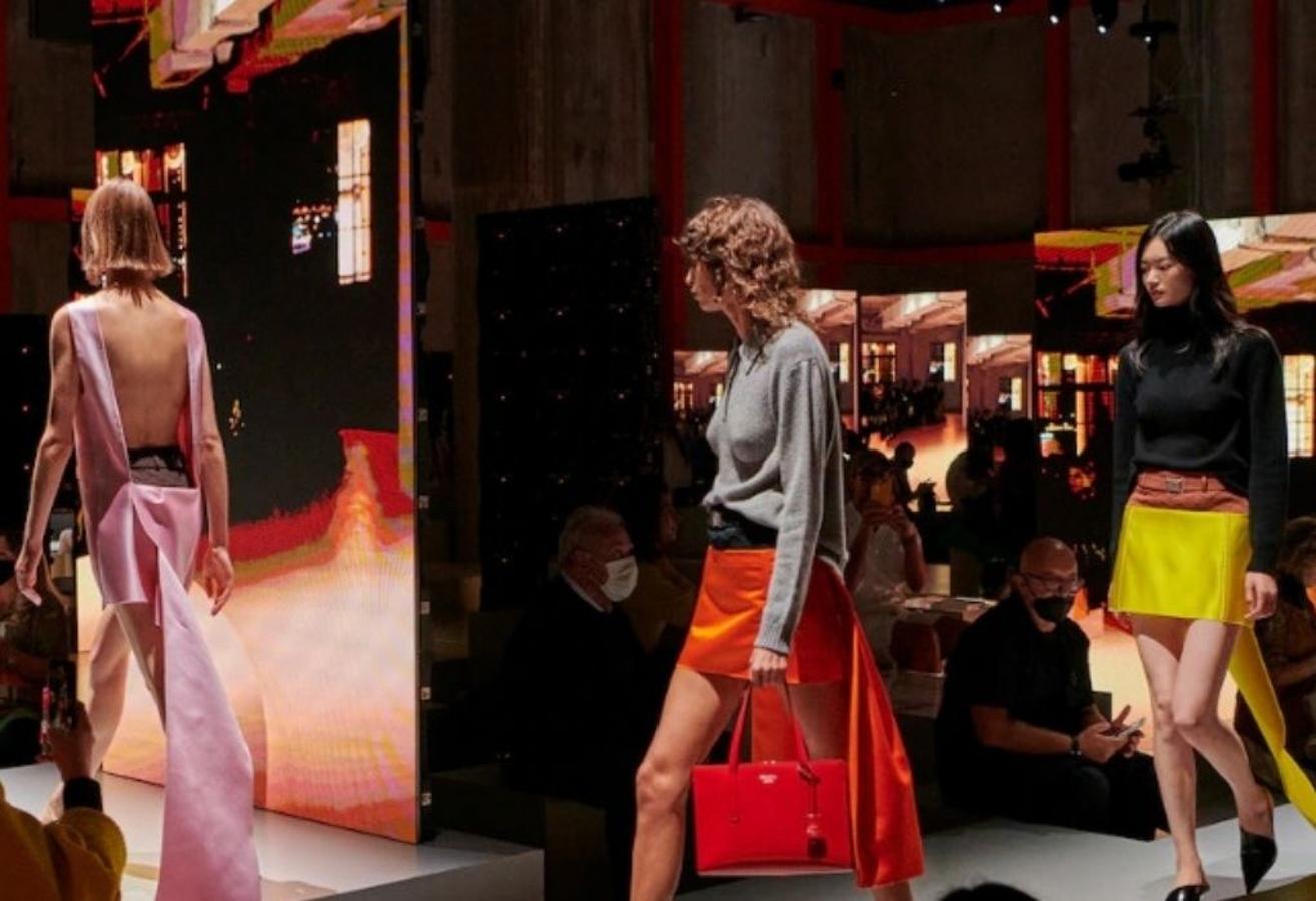 Prada - MFW primavera-verano 2022. Miuccia Prada y Raf Simons intentan sacar el lado más sensual de la mujer con una propuesta en donde las prendas de noche más ‘sexys’ se lucen en los looks diurnos y que se hacen patentes a través de pequeños detalles, como un corsé, la curva de un sostén o una cola improvisada. Una colección cargada de simbolismo con la que dejan claro que todavía tienen mucho que decir.