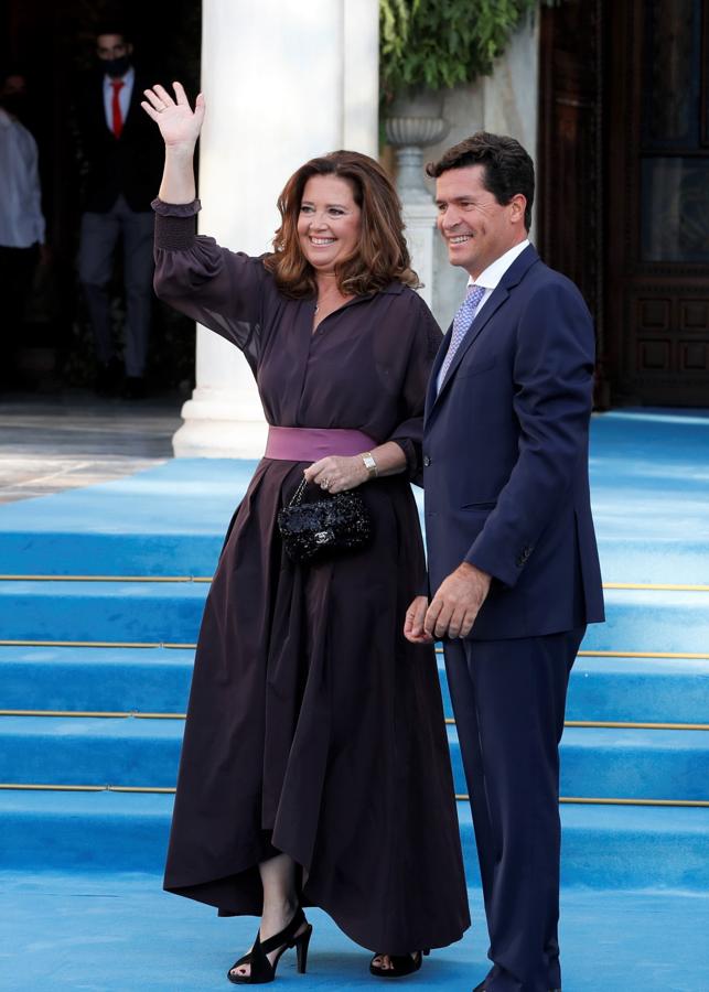 Alexia de Grecia y Carlos Morales. Lució un vestido berenjena con una falda asimétrica y un fajín rosa bebé que combinó con un minibolso de chanel y sandalias de tiras gruesas.