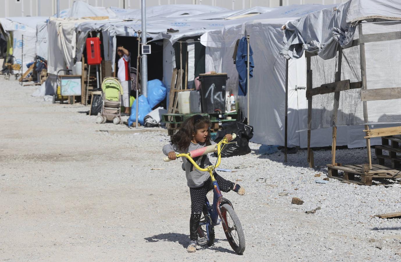 Una niña juega con su bicicleta por el campo de refugiados. 