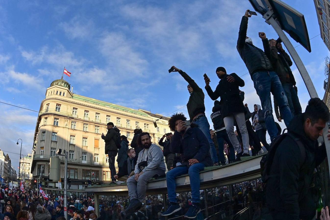 Varios manifestantes fotografían los alrededores durante las protestas contra las restricciones. 