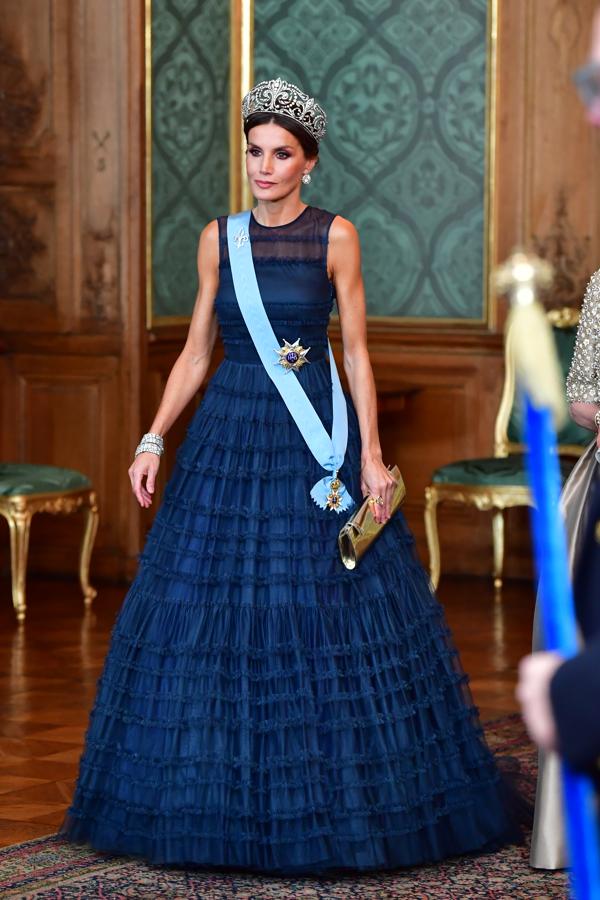 Un guiño a la moda sueca. El diseño de color azul noche, estaba confeccionado en poliéster reciclado y tul y se componía de un cuerpo ajustado con cuello a la caja y mangas de sisa que se ceñía a la cintura, marcándola al máximo, para terminar en una voluminosa falda repleta de pequeñas hileras de volantes. La prenda tenía un coste aproximado de 300 euros y un curioso detalle a resaltar es que Doña Letizia no ha sido la única royal en lucirlo, pues ya lo llevó la heredera al trono, Victoria de Suecia, en la conmemoración de su décimo aniversario (aunque en su caso modificó ligeramente el patrón añadiendo unas mangas).