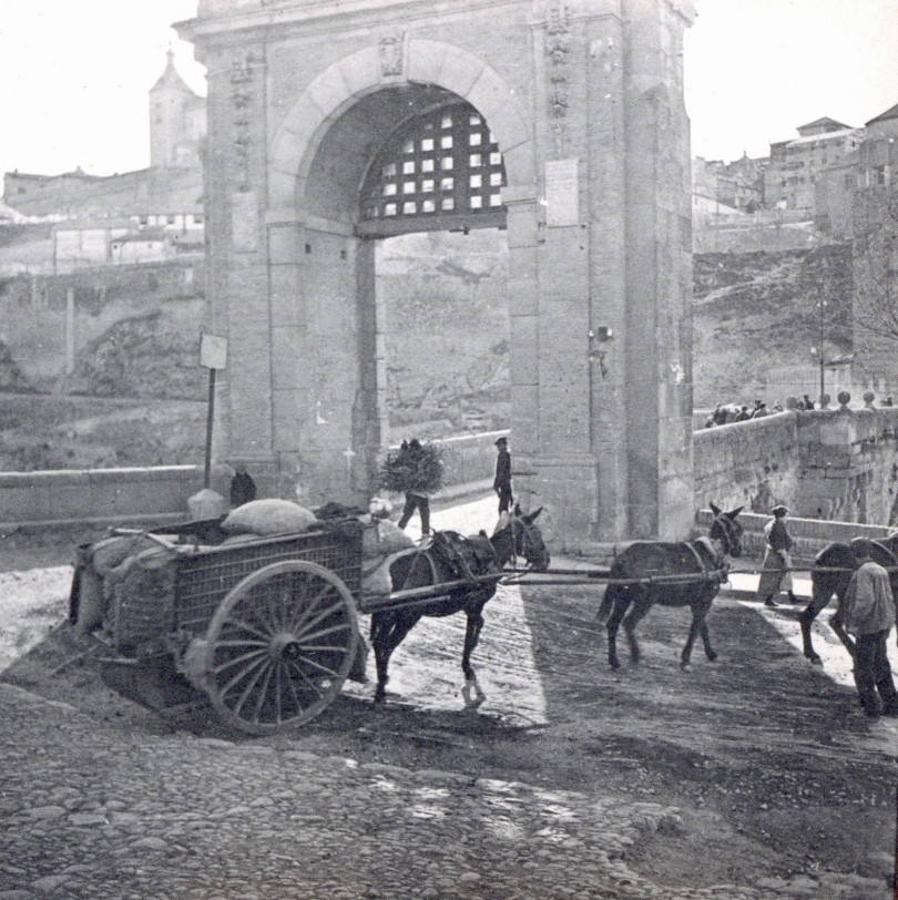 Carro y transeúntes en la salida del puente de Alcántara. Adolfo Landecho (1922). Archivo Municipal de Toledo. 
